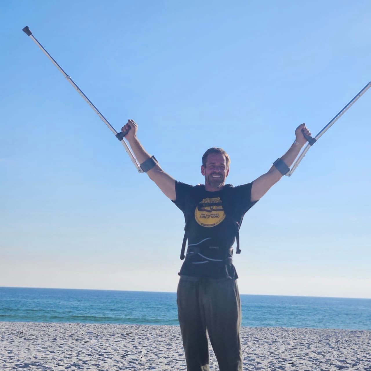 Michael Cavett on the beach with crutches
