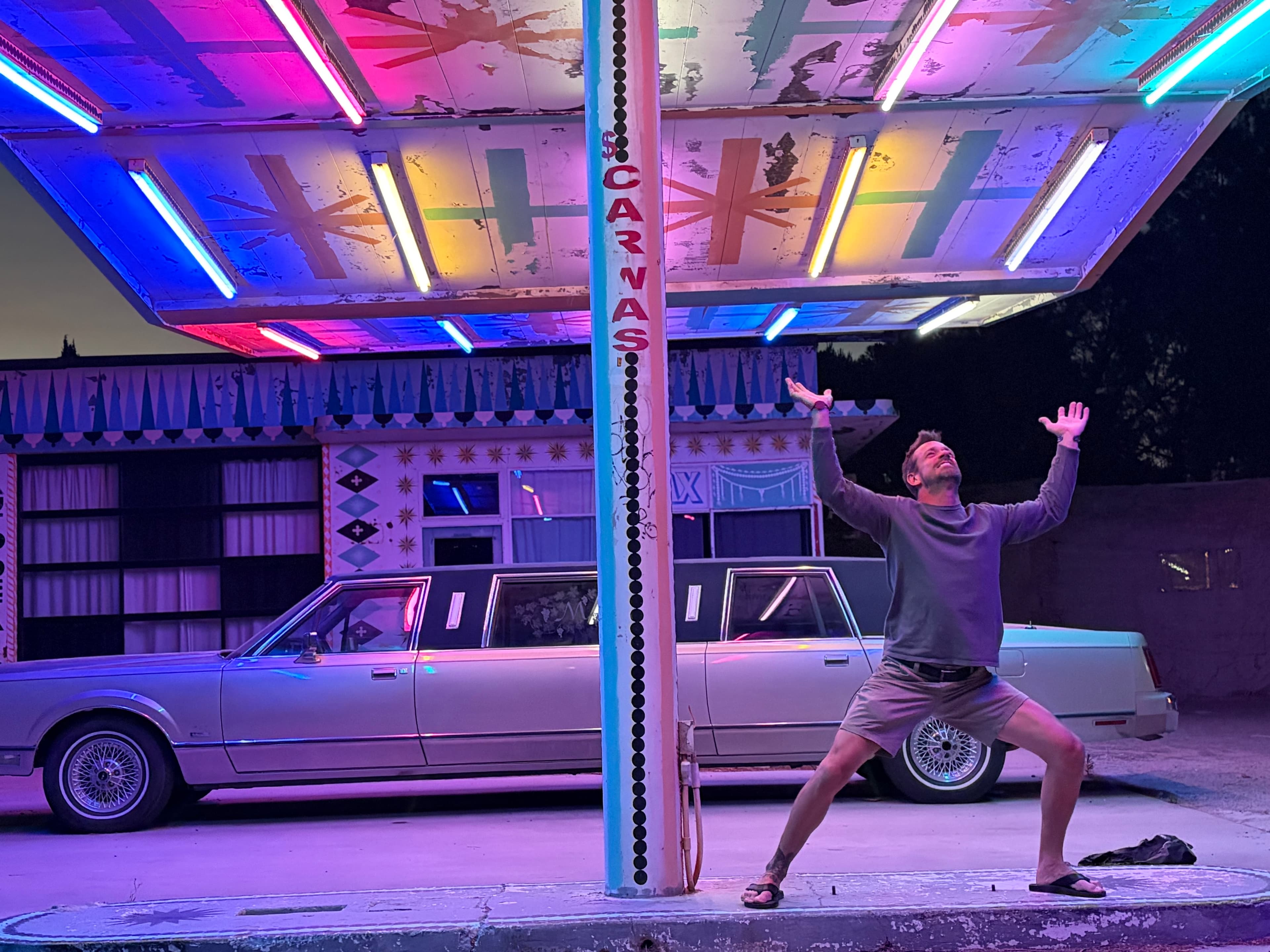 Michael Cavett standing at a neon-lit gas station