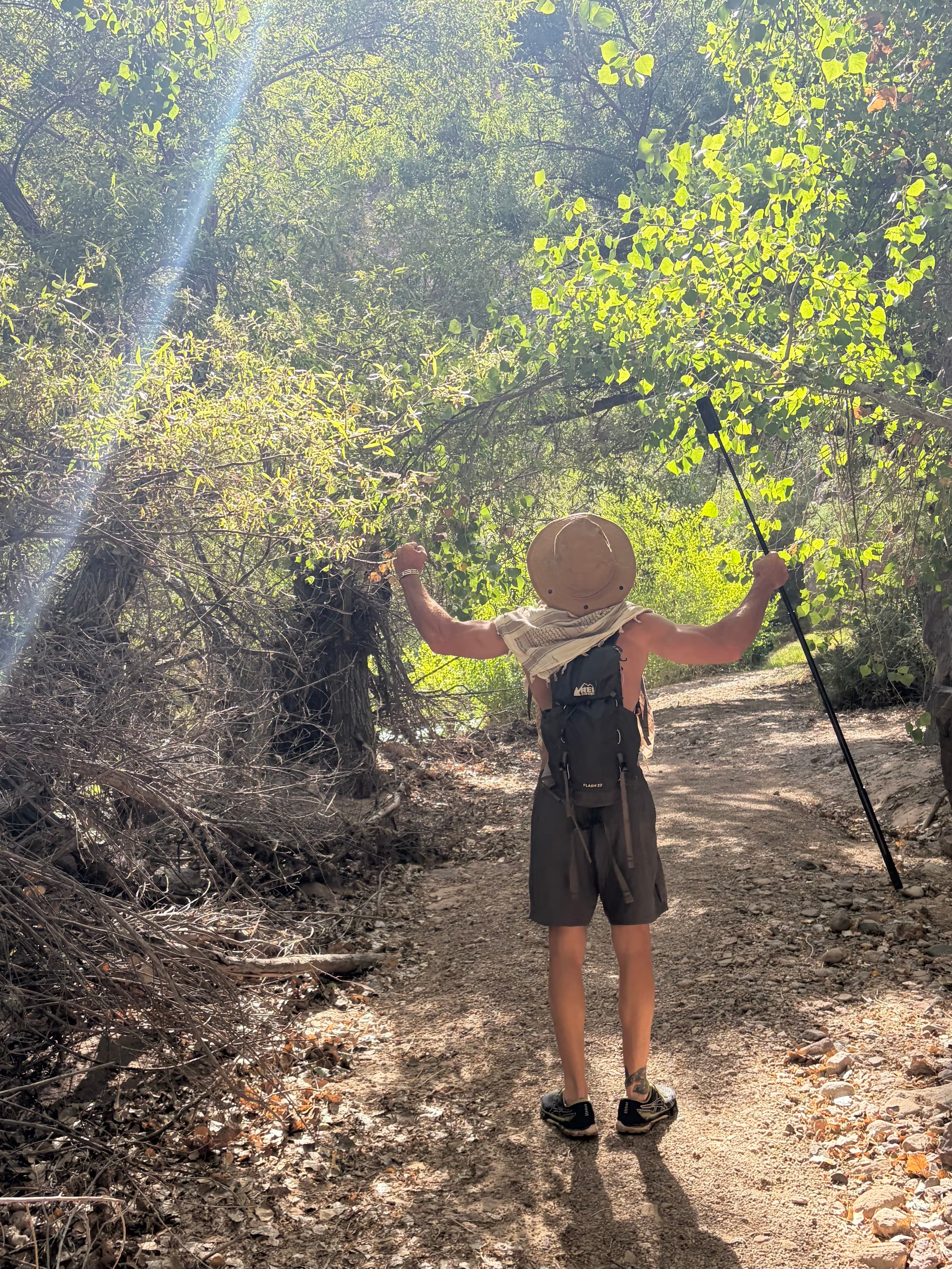 Michael Cavett raising his arms in celebration on a trail